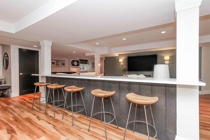 Built-In Bar Area With Five Stools in Finished Basement
