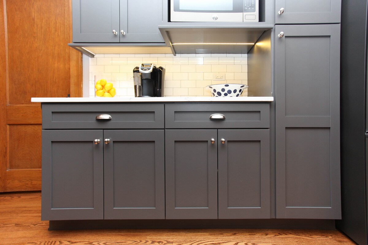 Gray shaker cabinets with vertical storage in kitchen remodel