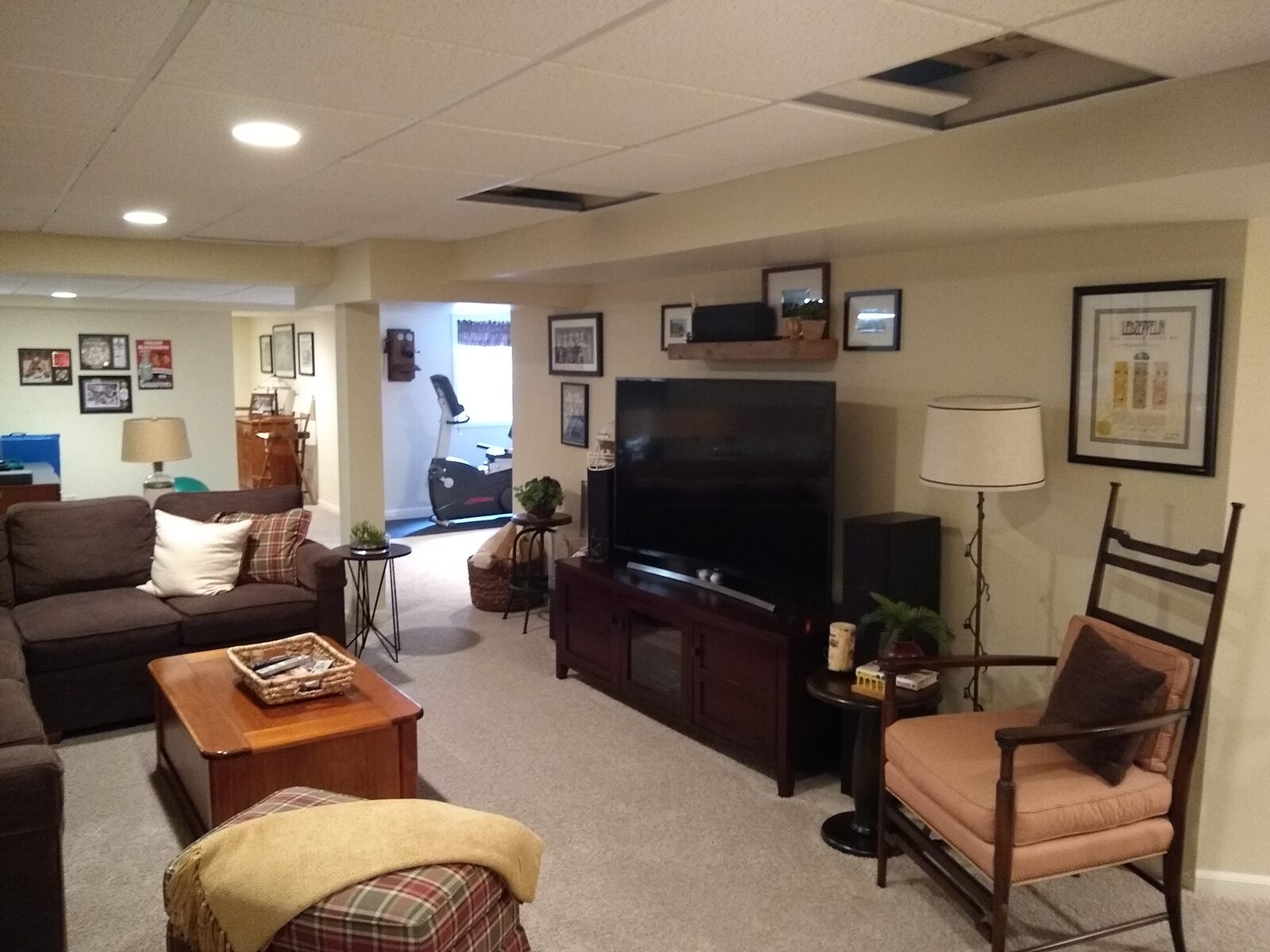 downstairs basement with tv and couches and exercise room in back in arlington heights