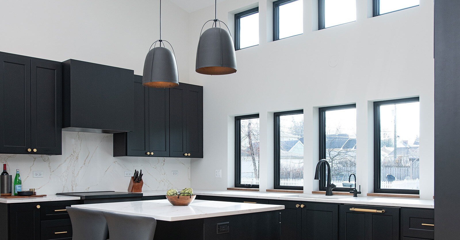 Contemporary kitchen work triangle layout showcasing a sink station beneath large windows opposite the main cooktop and island.