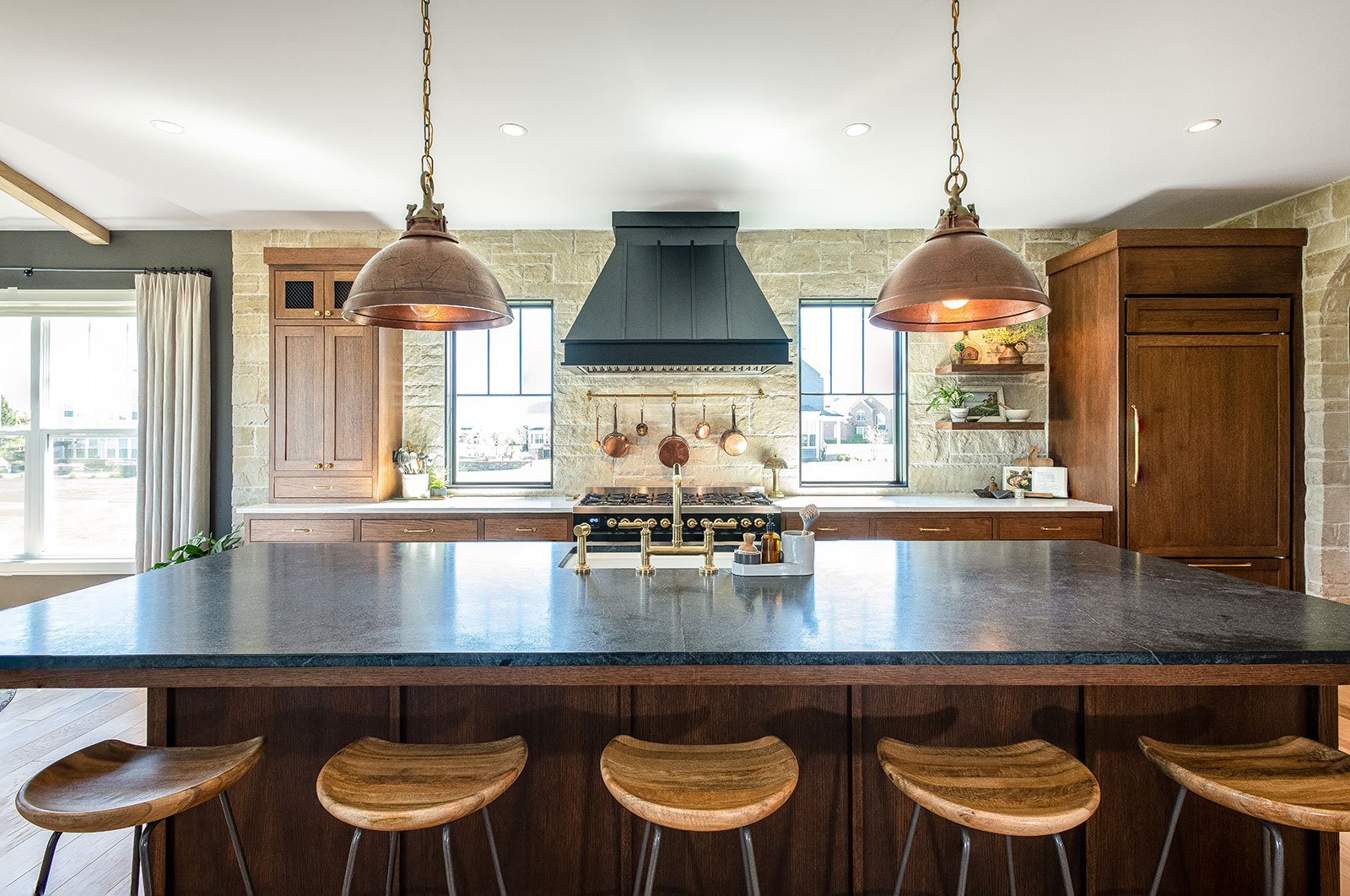 Open-plan kitchen renovation highlighting the multi-functional work island, defining the efficient cooking triangle while simultaneously separating it from guest seating.