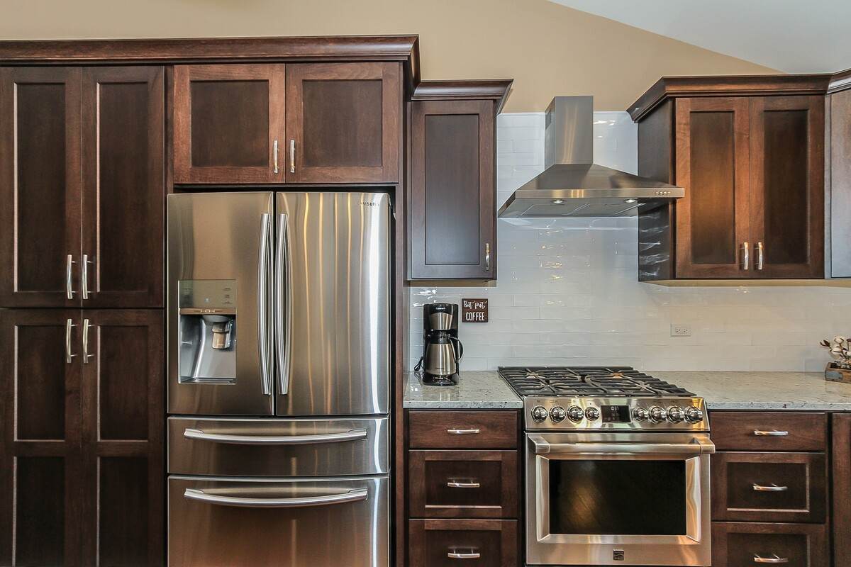 Modern kitchen remodel with stainless steel appliances and range hood