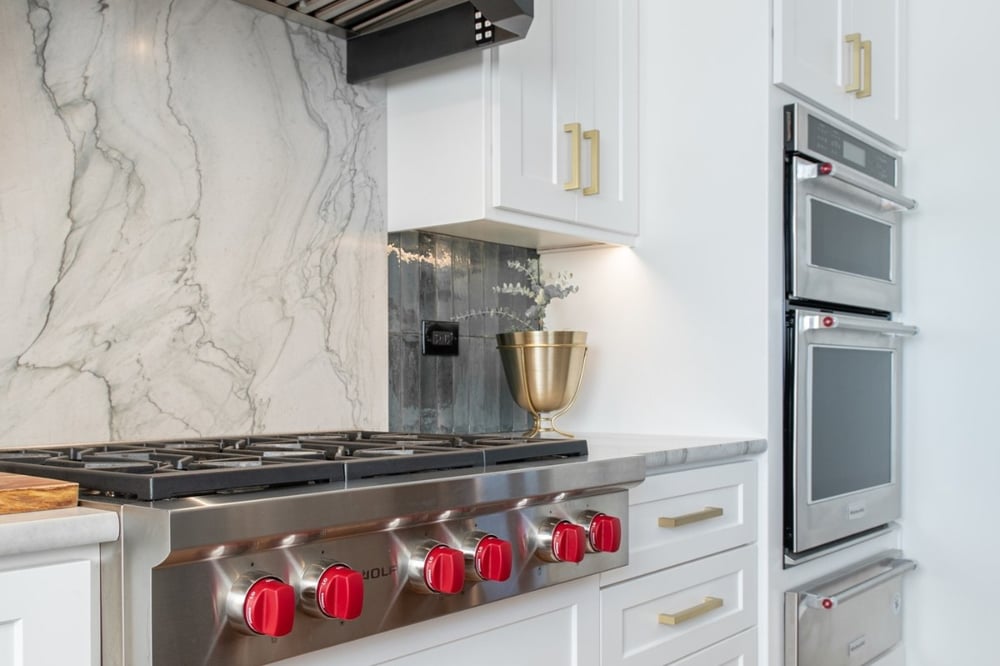White transitional kitchen remodel with slab backsplash behind cooktop